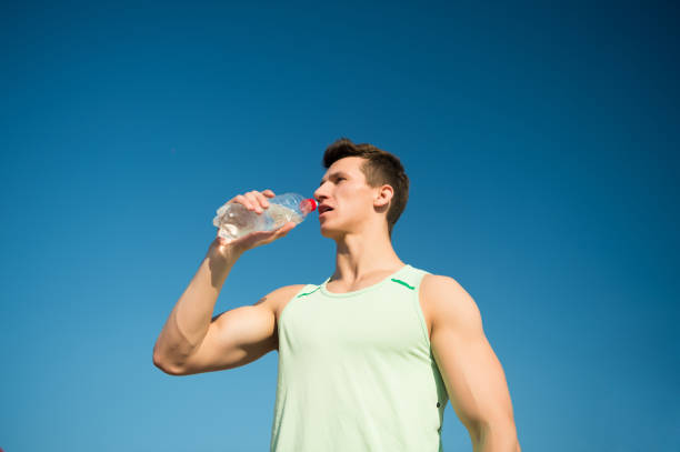 istock Man drinking water from bottle on sunny day 1346111455