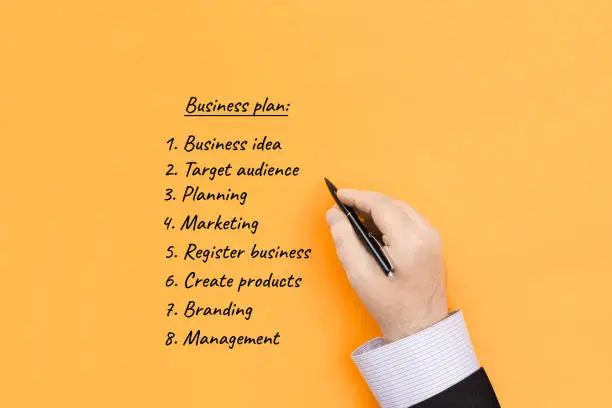 Business plan creation. The businessman writes down the main ideas of business development.