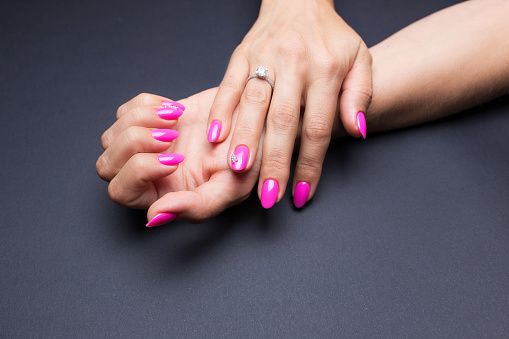 Stylish manicure pink on a black background