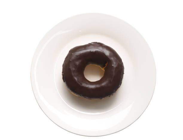 istock A chocolate glazed donut on small white plate isolated on white background 1346117807