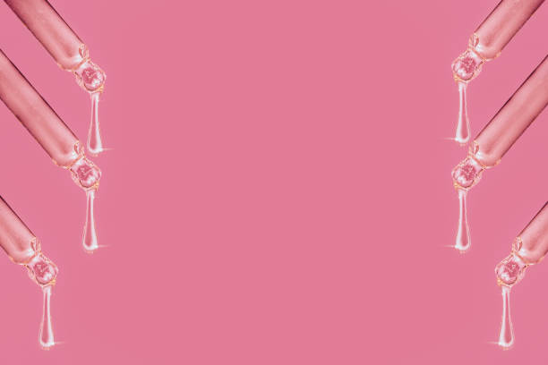 istock Pink background with pipettes and drops of liquid. 1346118524