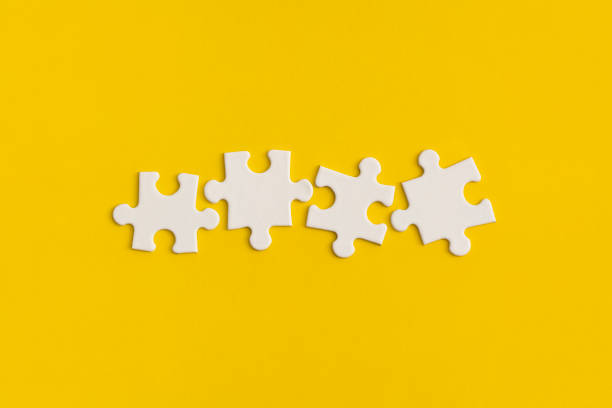 istock White details of puzzle on yellow background. 1346120153