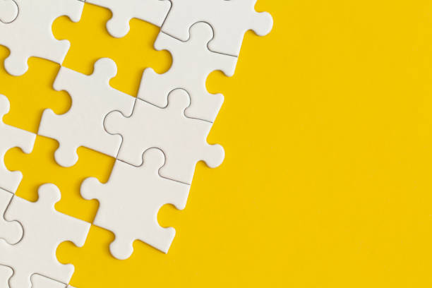 istock White details of puzzle on yellow background. 1346120155