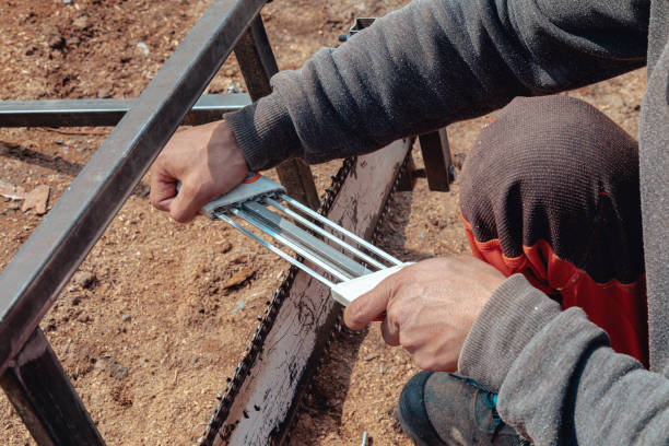 istock Closeup of lumberjack sharpening a chainsaw with file 1346120940