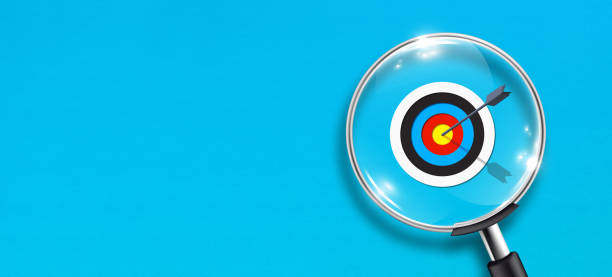istock Target concept with magnifying glass on blue background with copy space 1346120980