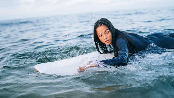 istock Asian female surfer in sea 1346121035