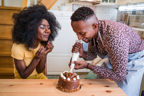 istock Couple in love decorating a cake at home 1346123392