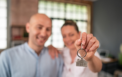 Mid adult couple holding the keys to their new home