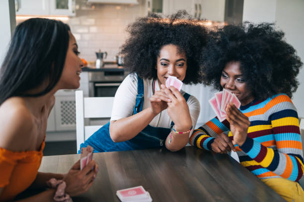 istock Three girls at home playing cards 1346123431