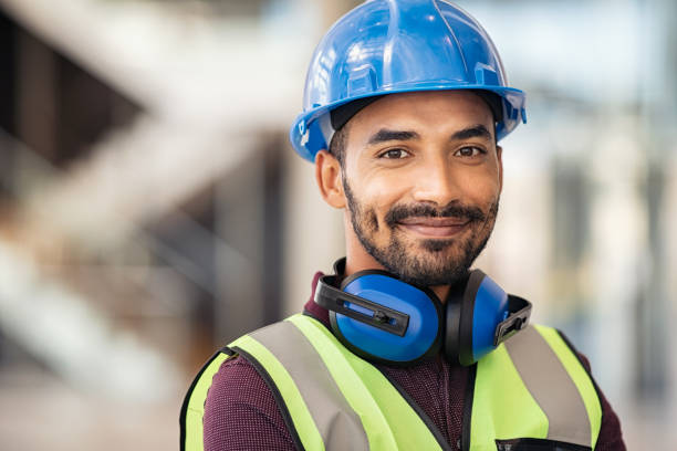szczęśliwy pracownik budowy mieszanej rasy patrzący na kamerę - construction safety protective workwear hardhat zdjęcia i obrazy z banku zdjęć