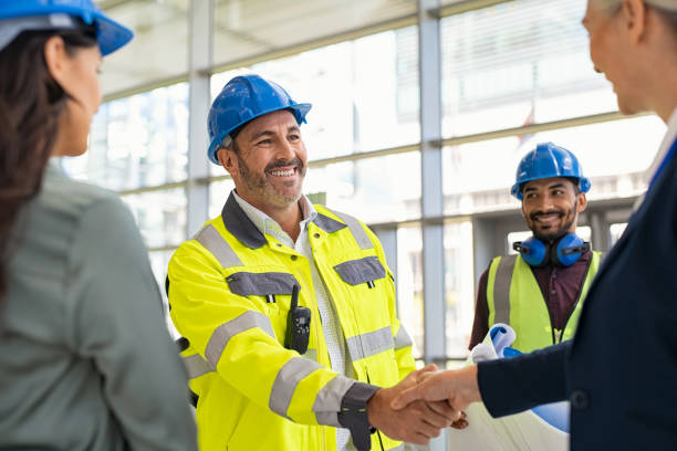 arquitecto y contratista maduro dándose la mano en el sitio de construcción - hardhat construction men handshake fotografías e imágenes de stock