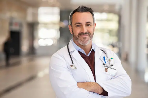 Photo of Confident successful mature doctor at hospital