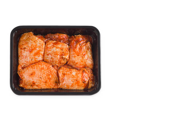istock Chicken semi-cooked thighs. isolated object.Raw chicken thighs marinated in red sauce. Top of view. Raw chicken marinated. copy space. 1346124902