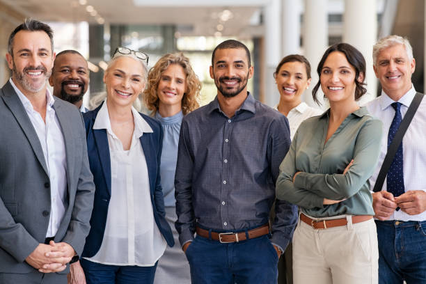 Group of successful multiethnic business team Portrait of successful group of business people at modern office looking at camera. Portrait of happy businessmen and satisfied businesswomen standing as a team. Multiethnic group of people smiling and looking at camera. business stock pictures, royalty-free photos & images