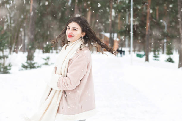 istock Merry lady walking in the forest during snowfall 1346125611