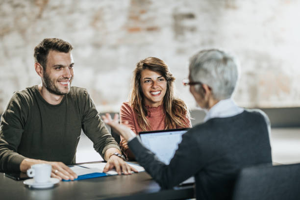 istock Happy couple having a meeting with their insurance agent. 1346126582