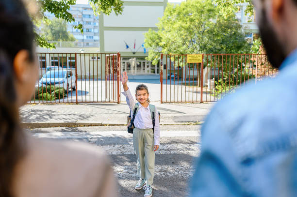 istock Mother and father taking her daughter to school 1346128160