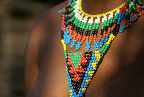 Traditional necklaces, made by local people in South Africa, on the neck of the local young lady, were spotted in the late afternoon. The beautiful atmosphere created by the sun playing with the vivid colours of the necklace and her skin.