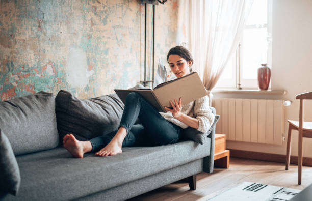 istock woman at home lying down reading a book during the outbreak 1346129269