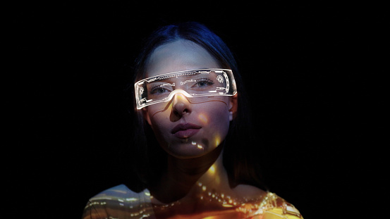 Projection on a woman's face wearing futuristic glasses.