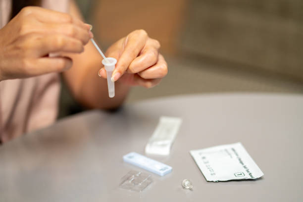 istock Asian woman using rapid antigen test kit for self test COVID-19 epidemic at home. 1346129630