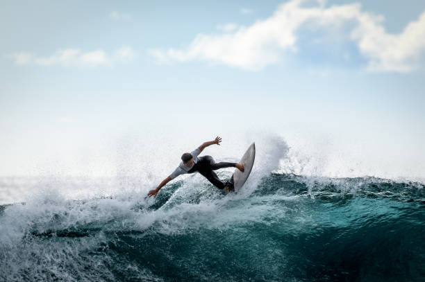 młody surfer z pianką cieszącą się dużymi falami na teneryfie na wyspach kanaryjskich. sportowe fale chłopięce - co surfing zdjęcia i obrazy z banku zdjęć