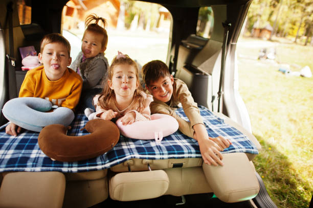 famiglia di quattro bambini all'interno del veicolo. bambini nel bagagliaio. viaggiare in auto, sdraiarsi e divertirsi, concetto di atmosfera. - 12 23 mesi foto e immagini stock