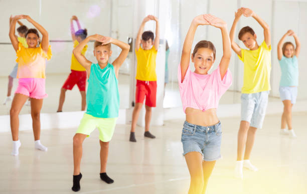 istock Group of children are learning dance moves in modern studio 1346135498