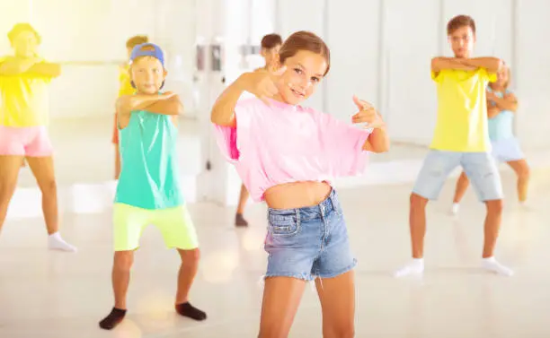 Photo of Tween girl krump dancer in choreographic studio with children