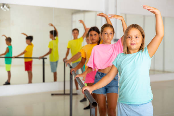 istock Smiling tween girl practicing classic dance moves near ballet barre 1346135548