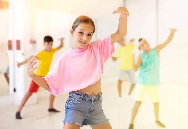 Photo of Tween girl breakdancer posing during group dance class