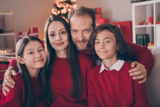 ภาพของหวานเสน่ห์พ่อแม่ลูกสองคนแต่งตัวเสื้อกันหนาวสีแดงโอบกอดรอปีใหม่ยิ้มในบ้านห้องบ้า� - การถ่ายภาพ ภาพ ภาพถ่าย ภาพสต็อก ภาพถ่ายและรูปภาพปลอดค่าลิขสิทธิ์