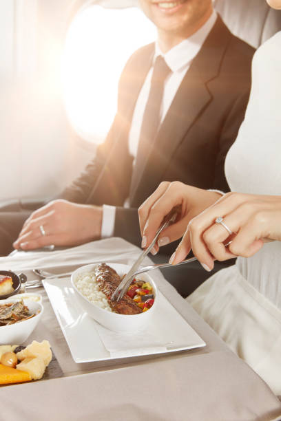 Having business class airplane food Young couple having business class food in an airplane cabin airplane food stock pictures, royalty-free photos & images