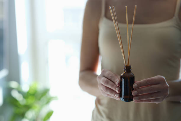 bouteille avec bâtonnets d’encens dans les mains féminines en gros plan - air freshener photos et images de collection