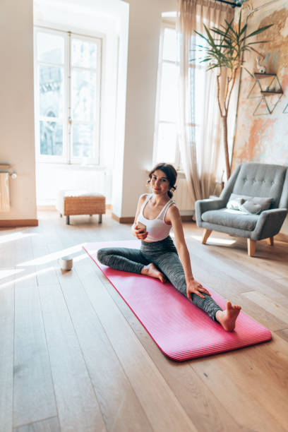istock woman doing yoga at home and text messaging 1346138003