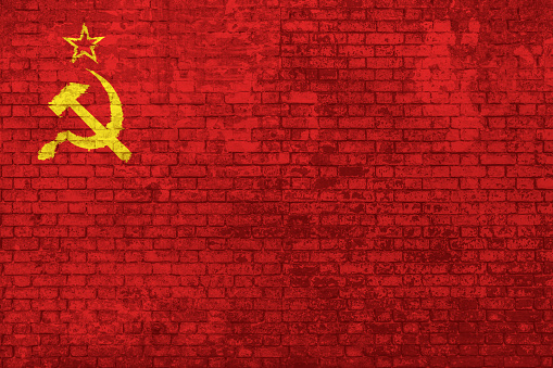Wall of bricks painted with the Flag of the old Soviet Union, adopted from 12 November 1923 to 15 August 1980. Concept of social barriers, divisions, and political conflicts in 1980s. 3D background.