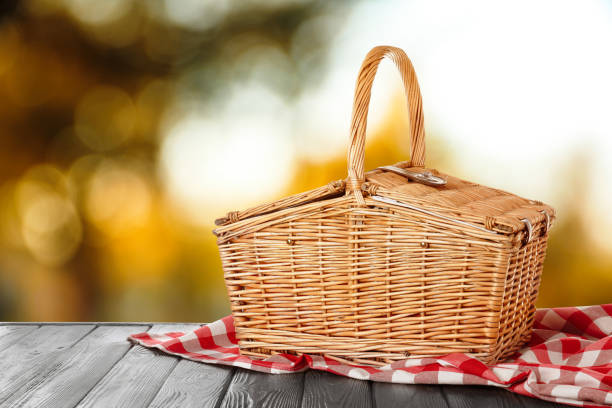 istock Wicker picnic basket on wooden table outdoors, space for text 1346140747