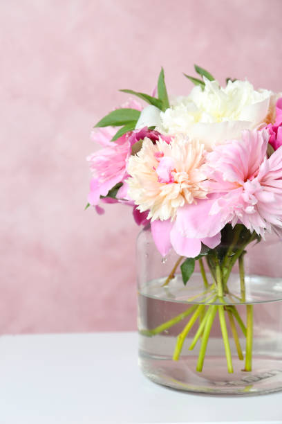 istock Bouquet of beautiful peonies in vase on white table 1346140973