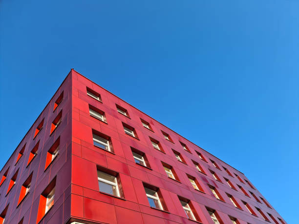 istock Multi-storey red building standing against blue sky background 1346141076