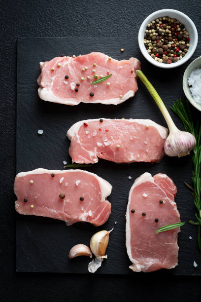 istock Raw uncooked meat slice on slate and spice top view 1346141303