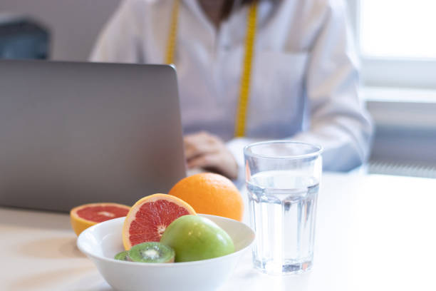 istock dietitian woman working with her computer and an office with mixed fruit and water on the table 1346141965