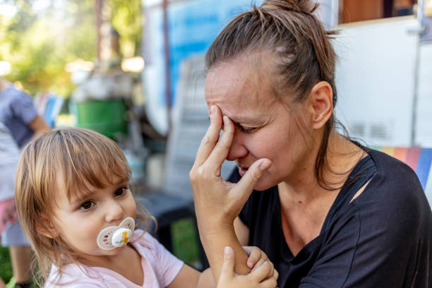 istock A sad and depressed young mother is sitting in the backyard, feeling exhausted while her daughter is next to her. 1346142140