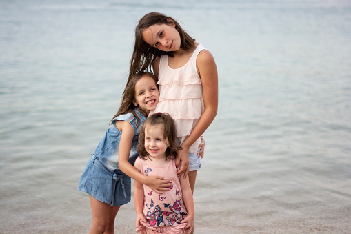 Portrait of three cute sisters at the beach