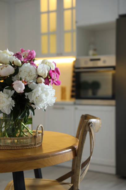 istock Beautiful peonies in vase on wooden table in kitchen 1346143011