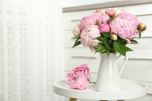Artificial blooming peonies and pink candle decoration
