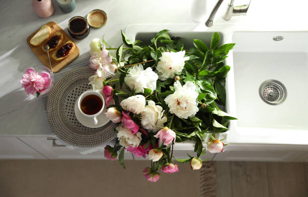 istock Beautiful peonies and breakfast on kitchen counter, flat lay 1346144563