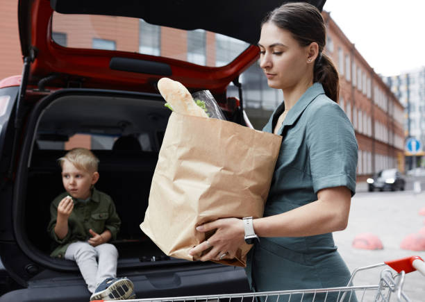 istock Young Mother Putting Bag In Car Trunk 1346144652