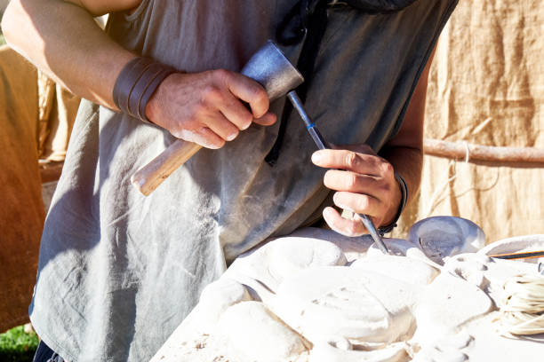 Craftsman carving stone in a traditional way. Concept of traditional and manual work stock photo