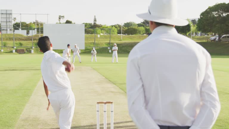 Rear view of cricket payer throwing a ball