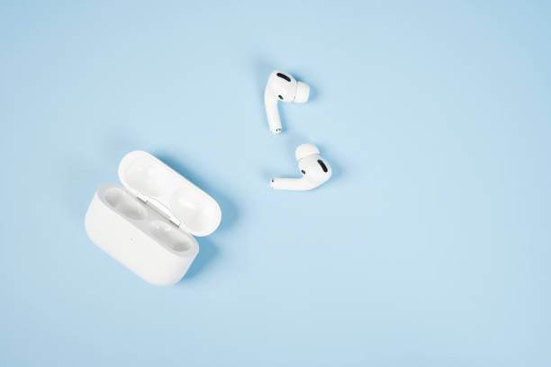 nowoczesne bezprzewodowe słuchawki bluetooth z etui ładującym na niebieskim tle. - bluetooth zdjęcia i obrazy z banku zdjęć